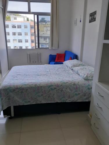 Schlafzimmer mit einem Bett und einem Fenster in der Unterkunft Apartamento Temporada Dalva Copacabana in Rio de Janeiro
