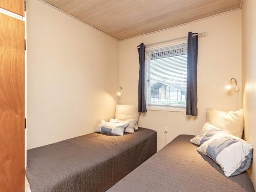 two beds in a small room with a window at Beachfront Family Retreat - By Traum Ferienwohnungen in Næs
