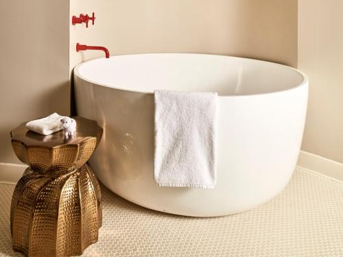 a white bath tub in a bathroom with a towel at Virgin Hotels Dallas in Dallas