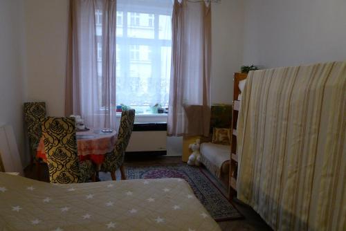 プラハにあるCozy modest room for 2 or 3 personsのベッドルーム1室(ベッド1台、テーブル、窓付)