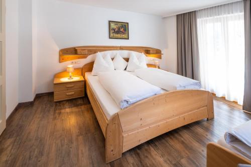 ein Schlafzimmer mit einem Holzbett mit weißen Kissen in der Unterkunft Villa Daringer in Mayrhofen