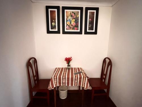 una mesa con un jarrón de flores. en Casa hospedaje Ingeniería - Lima, en Lima