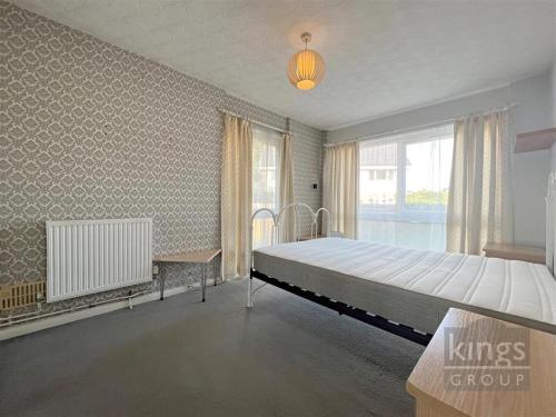 a bedroom with a large bed and a window at A cosy 1 bedroom apartment in Enfield