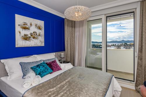 1 dormitorio con 1 cama grande y pared azul en DiVine Luxury Apartment Blue en Zadar