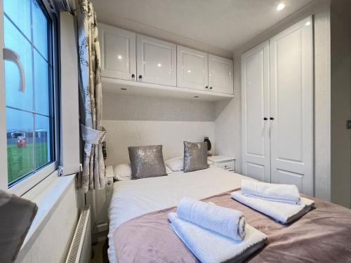 a bedroom with a bed with two towels on it at Stewarts Resort Lodge 4 in St. Andrews