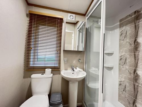 a bathroom with a toilet and a sink and a shower at Stewarts Resort Lodge 14 in St. Andrews