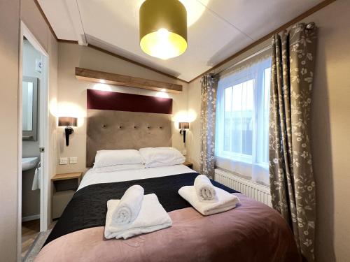 sypialnia z dużym łóżkiem z ręcznikami w obiekcie Stewarts Resort Lodge 14 w mieście St Andrews