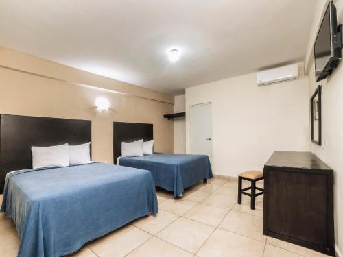 Habitación de hotel con 2 camas y mesa en Hotel Puerto Inn en Veracruz