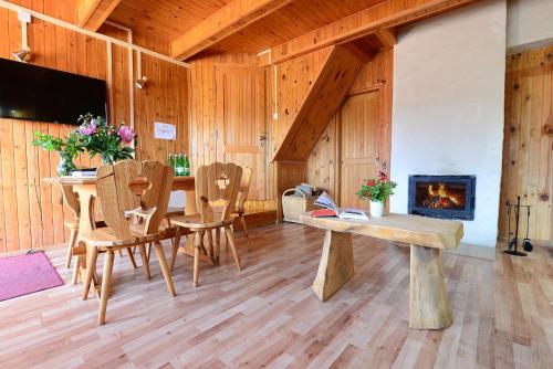 a dining room with a table and a fireplace at Perełka Bieszczady Domki in Cisna