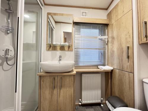 a small bathroom with a sink and a shower at Stewarts Resort Lodge 23 in St. Andrews