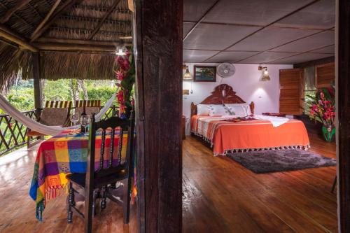 Un dormitorio con una cama y una hamaca. en Las Guacamayas Lodge Resort, Selva Lacandona, Chiapas México, en Tlatizapán