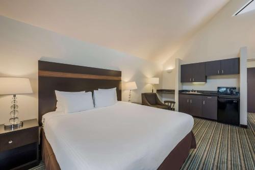 a hotel room with a large bed and a kitchen at Best Western Alderwood in Lynnwood