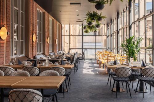 un restaurant avec des tables, des chaises et des fenêtres dans l'établissement Scandic Grand Central Helsinki, à Helsinki