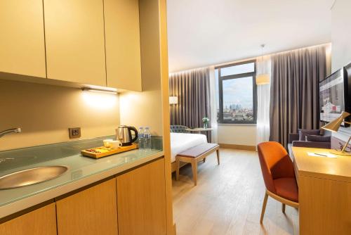 Radisson Hotel Istanbul Harbiye في إسطنبول: غرفة في الفندق مع حوض وغرفة نوم