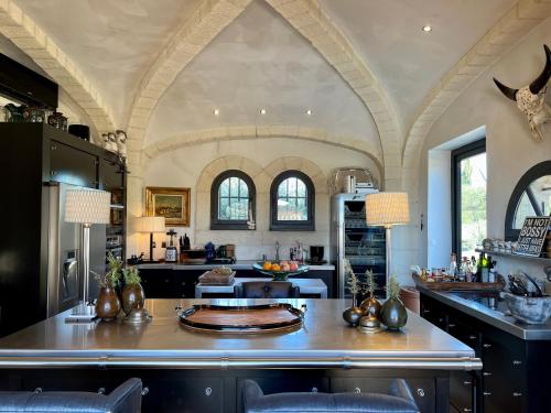 una gran cocina con una gran isla central con una mesa en Luxury Villa in front of the famous Pont-du-Gard., en Castillon-du-Gard