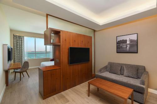 a living room with a couch and a tv at Radisson Resort Ras Al Khaimah Marjan Island in Ras al Khaimah