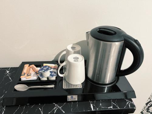 a black tray with a coffee pot and a cup at Sydney Boutique Hotel in Sydney