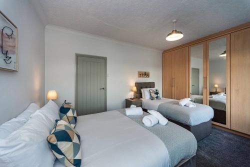 une chambre d'hôtel avec deux lits et une chambre dans l'établissement Cheerful 5 bed Property in Llanelli, à Llanelli