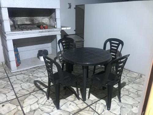 a black table and chairs in a kitchen with a stove at Departamento céntrico Villa Carlos Paz in Villa Carlos Paz