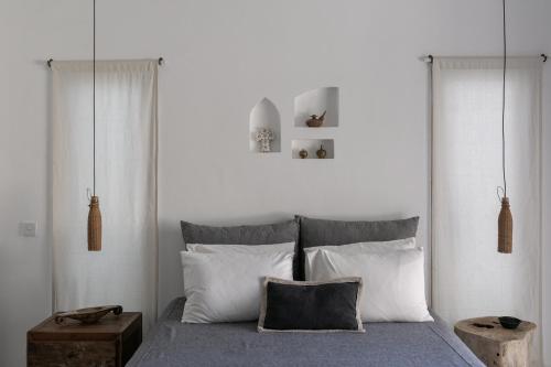 Schlafzimmer mit einem Bett mit weißen Wänden und weißen Kissen in der Unterkunft Villa Paz Bali in Canggu