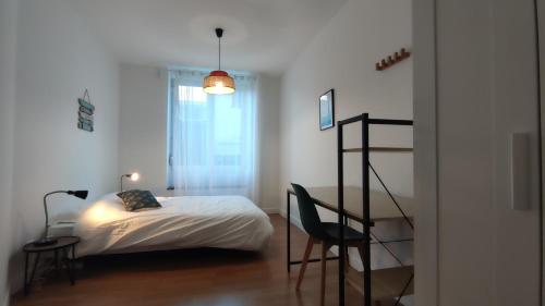 ein Schlafzimmer mit einem Bett, einem Schreibtisch und einem Stuhl in der Unterkunft Le Terracotta Ideal Groupe Salle de sport Parking Gratuit in Troyes