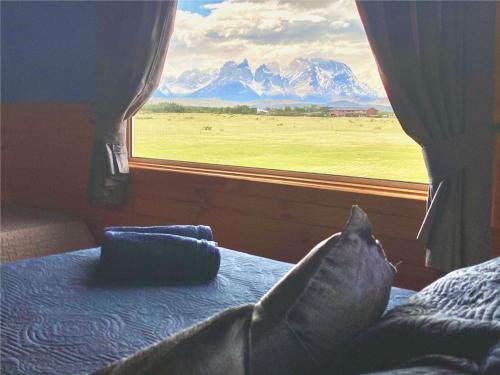 a bedroom with a window with a view of mountains at Vista al Paine - Refugio de Aventura in Torres del Paine