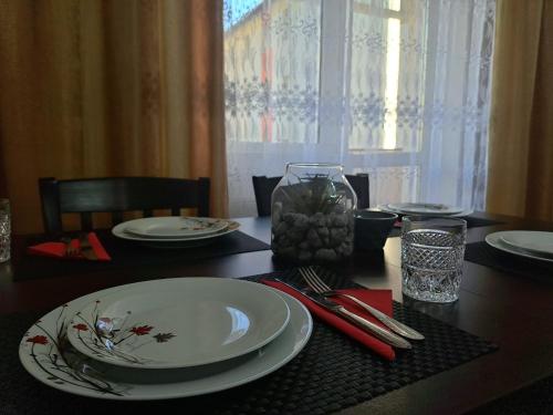 - une table à manger avec une plaque blanche et une serviette rouge dans l'établissement Aviliz Apartament Bușteni, à Buşteni