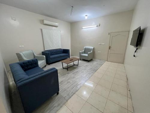 a living room with two blue couches and a tv at Albashier private apartment in AlUla