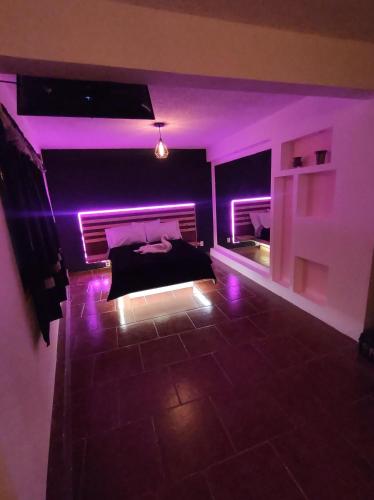 a room with purple lights in a bedroom at Cabañas Alicia in Mexico City