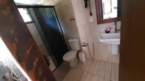 a bathroom with a shower and a toilet and a sink at Sossego Da Mata in Santo Antônio do Leite