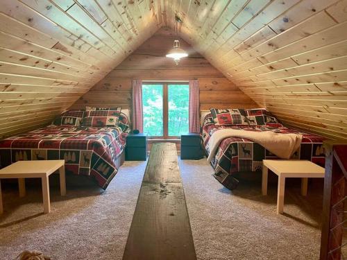 Habitación con 2 camas en una cabaña de madera en Camp Voyager Log Cabin resort pool, golf, trails, lakes more, en Webb Lake