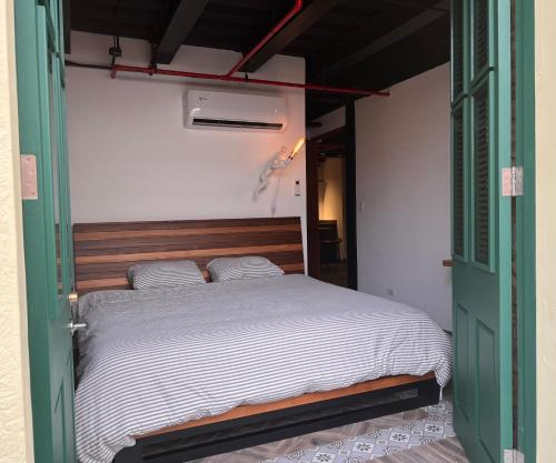 uma cama num quarto com uma porta verde em Corcho rooms em Cidade do Panamá