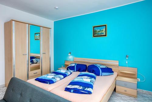 een slaapkamer met blauwe muren en een bed met blauwe kussens bij Apartments with a parking space Vodice - 6178 in Vodice