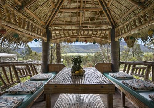 a wooden table with chairs on a porch with a view at Cants Cottage in Broke