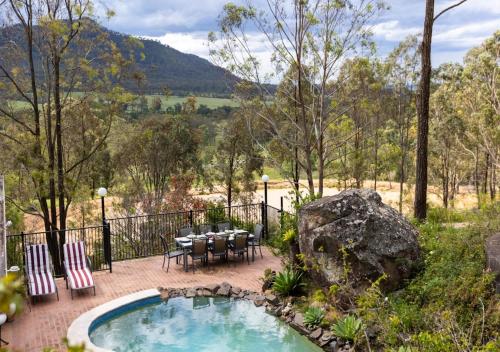 a pool with a table and chairs on a patio at Cants Cottage in Broke