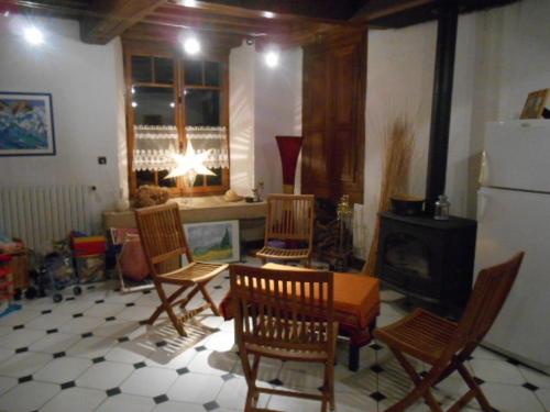 - un salon avec des chaises, une table et une cheminée dans l'établissement La Maison De Marie-Claire, à Doncourt-sur-Meuse