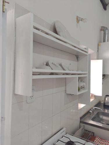 una cocina con armarios blancos y fregadero en Casa de Barro Tilcara en Tilcara