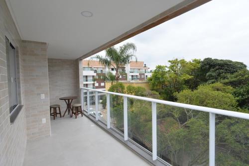 a balcony with a view of a table and chairs at Vila do Centro Apart Hotel in Bombinhas