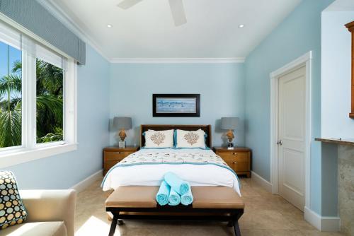 a bedroom with a bed with blue walls at The Regent Grand in Grace Bay
