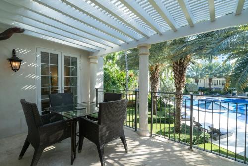 a patio with a table and chairs and a pool at The Regent Grand in Grace Bay