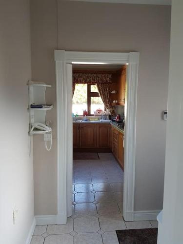 a kitchen with a door open to a kitchen with a window at Sunnyside Lodge - Beautiful Fermanagh Holiday Home in Tamlaght