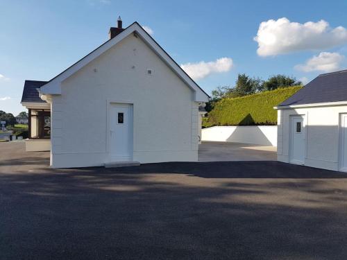 a white garage with a door in a driveway at Sunnyside Lodge - Beautiful Fermanagh Holiday Home in Tamlaght