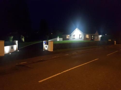 a house with lights on the side of a road at Sunnyside Lodge - Beautiful Fermanagh Holiday Home in Tamlaght