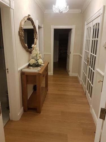 a hallway with a mirror and a table with flowers at Sunnyside Lodge - Beautiful Fermanagh Holiday Home in Tamlaght