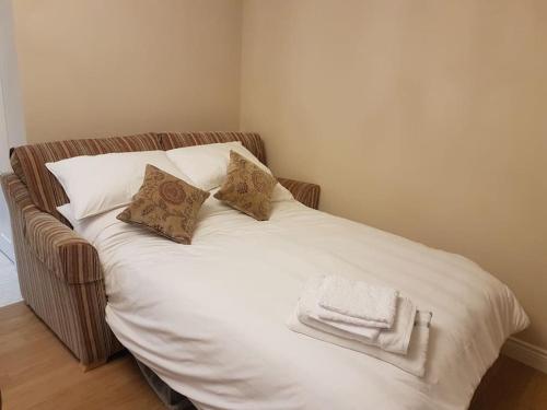 a bed with white sheets and pillows on it at Sunnyside Lodge - Beautiful Fermanagh Holiday Home in Tamlaght