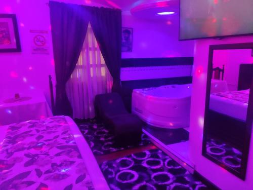 a purple room with a tub and a sink at Hotel el Che No apto para corruptos in Azogues