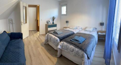 1 dormitorio con 2 camas y sofá en Maison agréable et spacieuse aux portes de Paris et du métro en Saint-Ouen