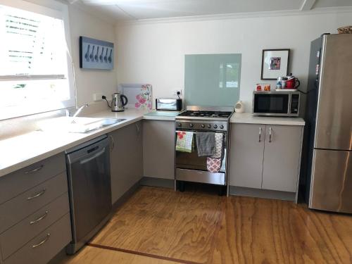 una cucina con lavello e fornello forno superiore di Ferntree Cottage a Mapua