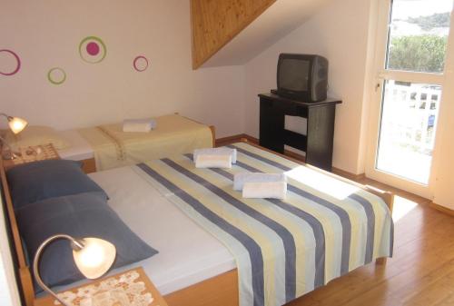 a small bedroom with two beds and a tv at Apartments and rooms with WiFi Hvar - 20114 in Hvar