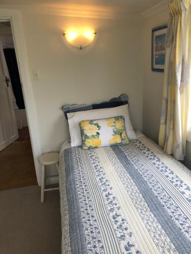 Mapua的住宿－Ferntree Cottage，一间卧室配有一张带蓝色和白色棉被的床